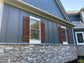 Blue house accentuated with rustic cedar shutters