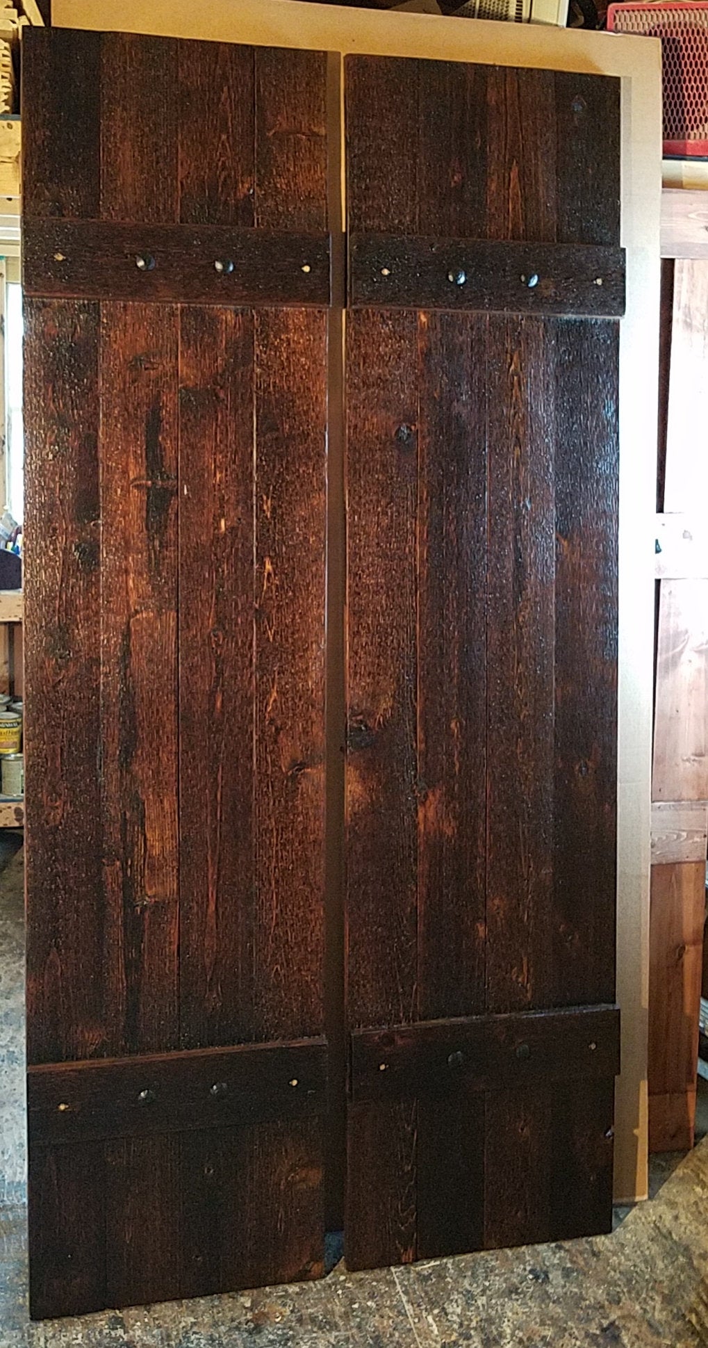 Double doors with rustic cedar shutters and metal hardware