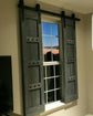 Television room window with a single wooden barn shutter