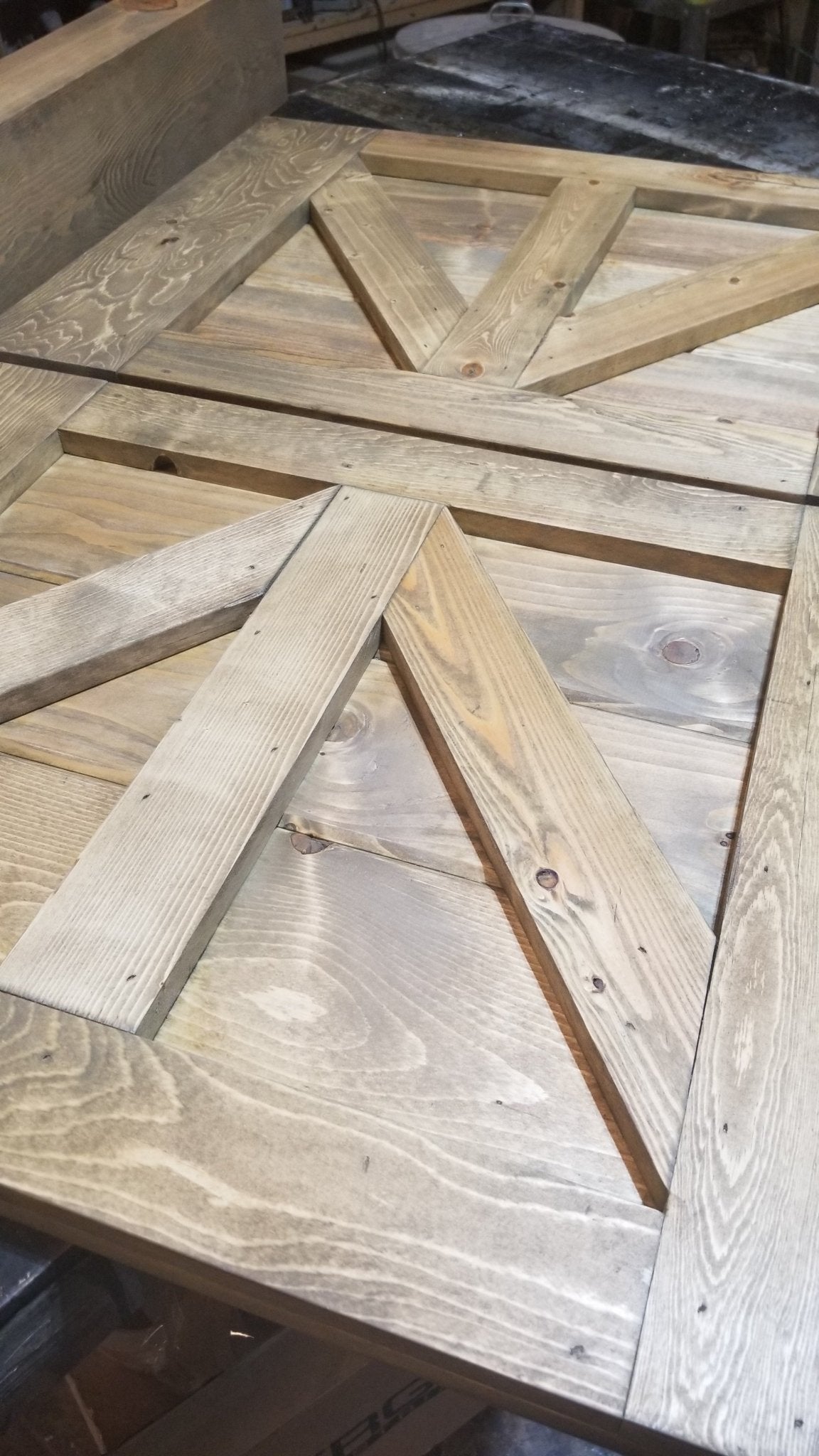 Detailed view of the wooden frame and top of the TV Barn Door Package driftwood stain